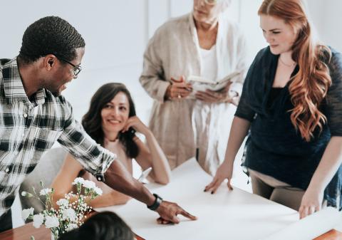 Group of four coworkers collaborating around a table